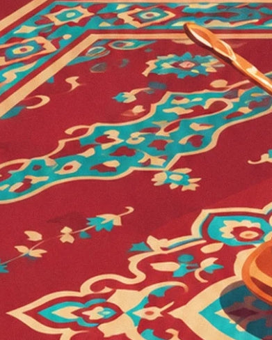 Le tapis rouge aux motifs turquoise et crème, bordé d’une cuillère cuivrée