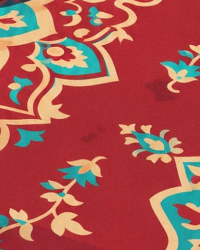 Les fleurs turquoise et crème et leurs tiges sinueuses sur le tapis rouge