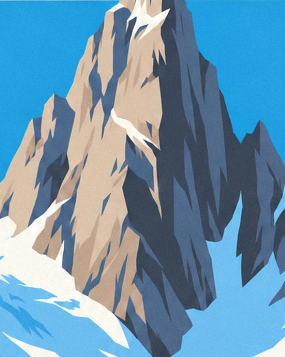 A beige and grey rock spire rising against the blue sky, with snow at its foot