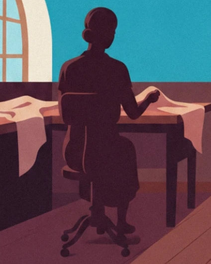 The dressmaker seen from behind, seated in front of fabrics spread across her table