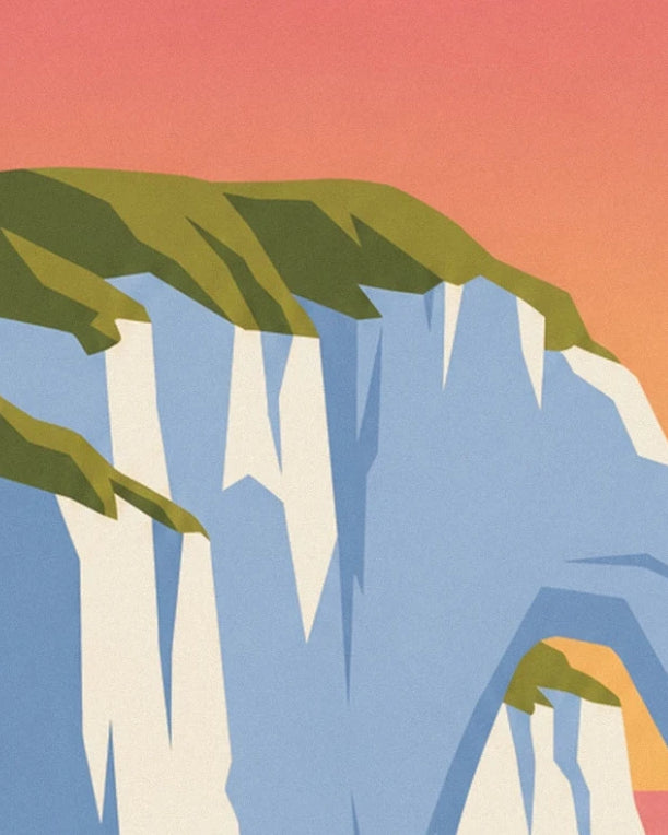 The white cliffs of Étretat topped with green grass beneath an orange sky