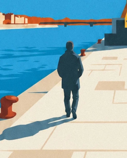 Un promeneur de dos sur le quai clair, entre bollards rouges et Loire bleue