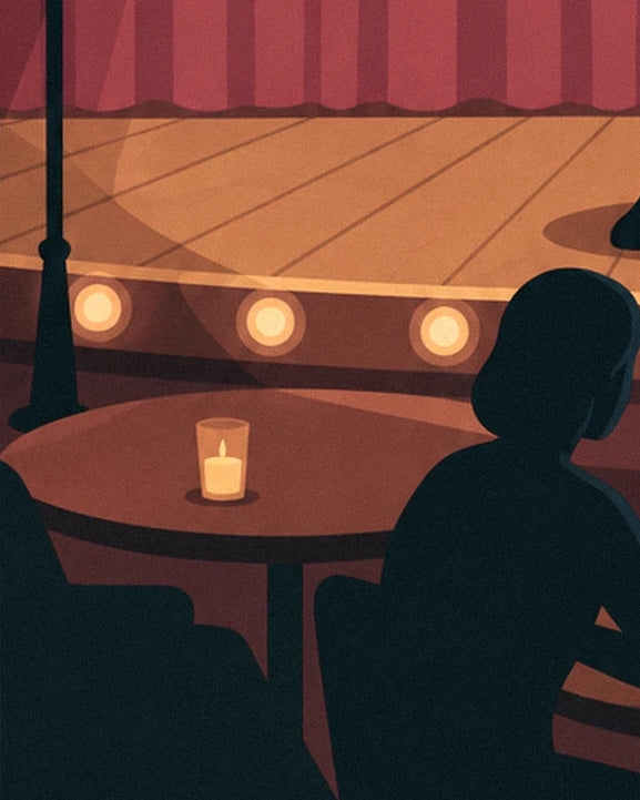 A candle on its round table, and the silhouette of a woman in the audience facing the stage