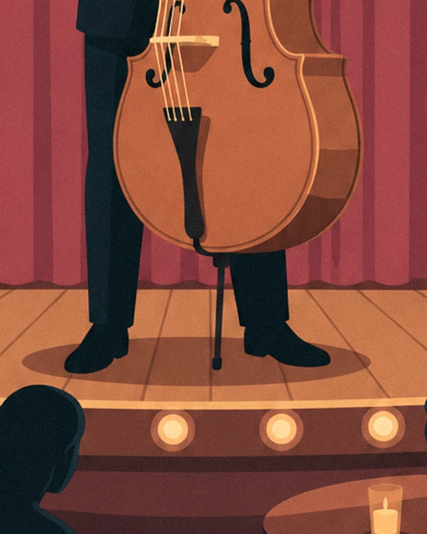 The pale wooden double bass and the musician's black shoes, on the lit stage