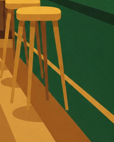 Tall light wood stools lined up along the green bar