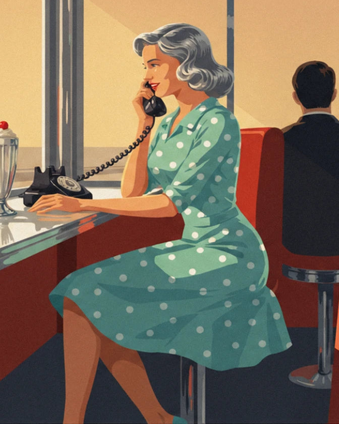 Une femme en robe verte à pois blancs au téléphone noir, assise au comptoir du diner