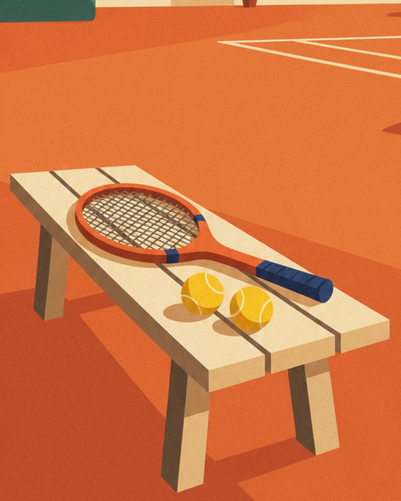 A wooden racket and 2 yellow balls resting on a bench beside the clay court