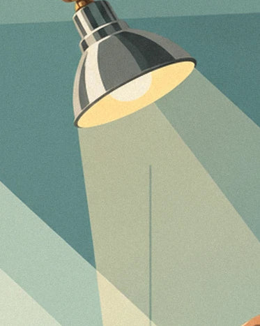 Une lampe d’atelier en métal gris et son large faisceau jaune sur le mur vert