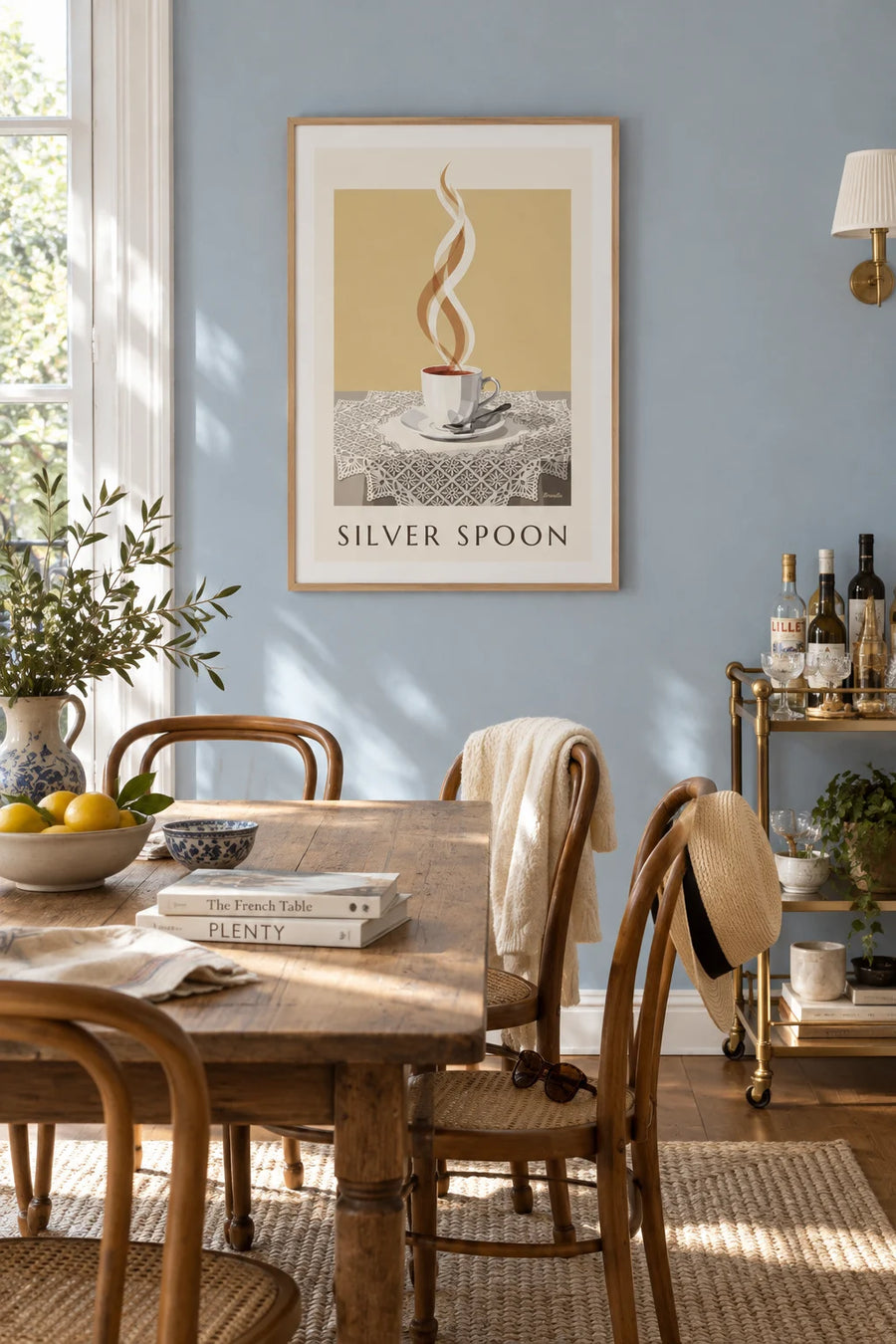 Poster of a steaming coffee cup and silver spoon on lace: framed on the wall