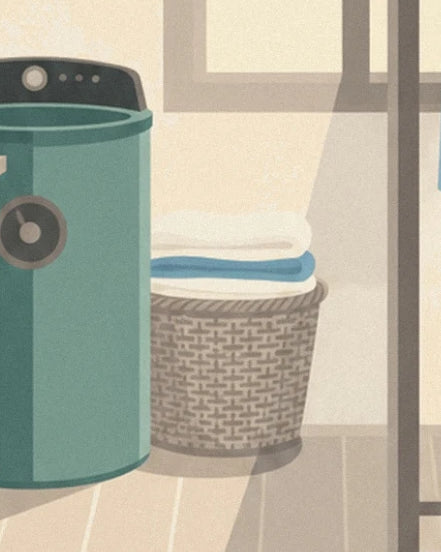 La machine verte et son panier d'osier garni de linge plié blanc et bleu, près de la fenêtre