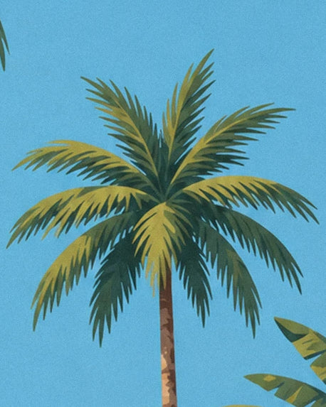 Un palmier aux longues palmes vertes et dorées sur le ciel bleu de Martinique